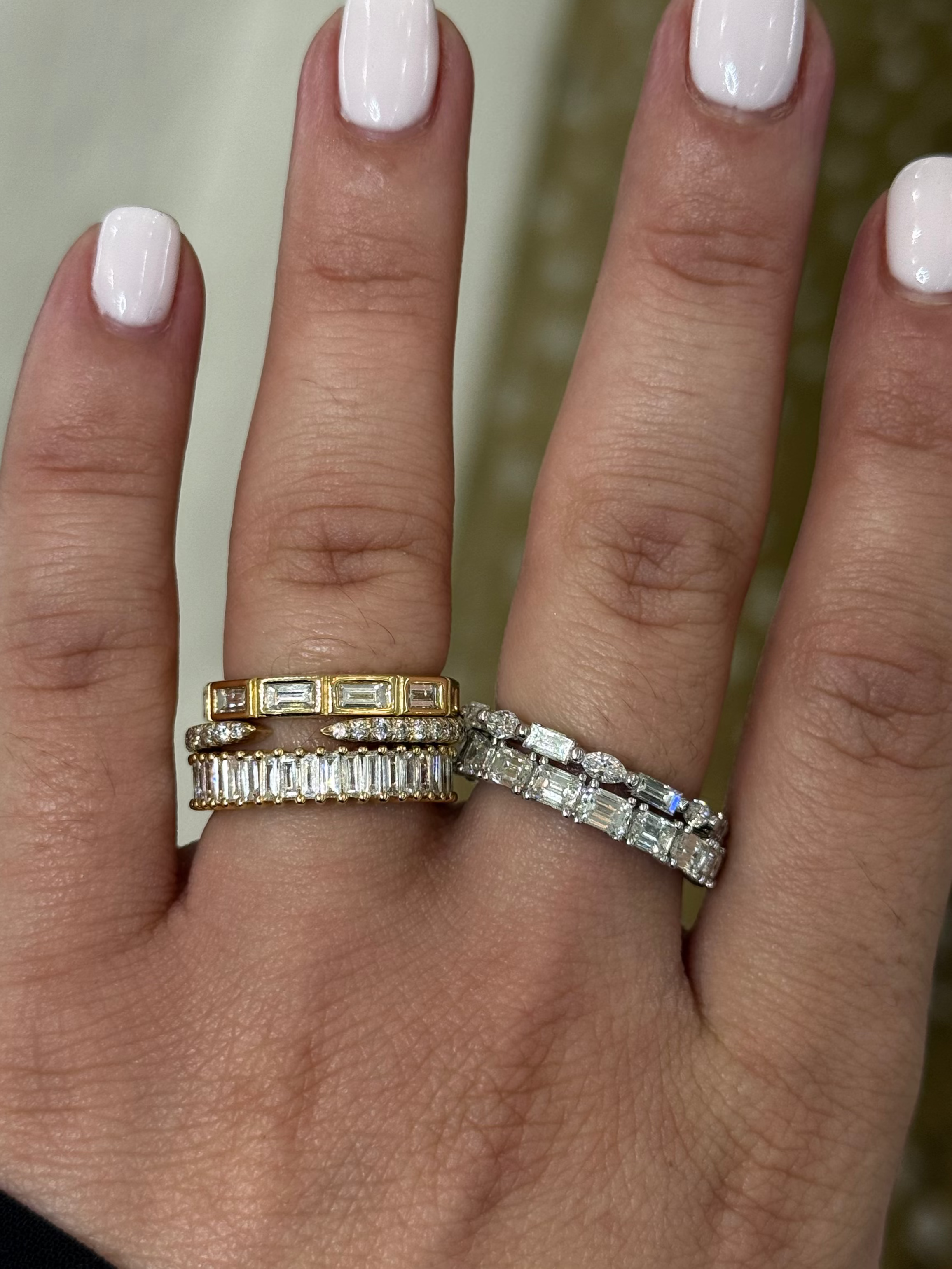 3 diamond rings on one finger, 2 diamond bands on the other. image of the hand with rings on them 