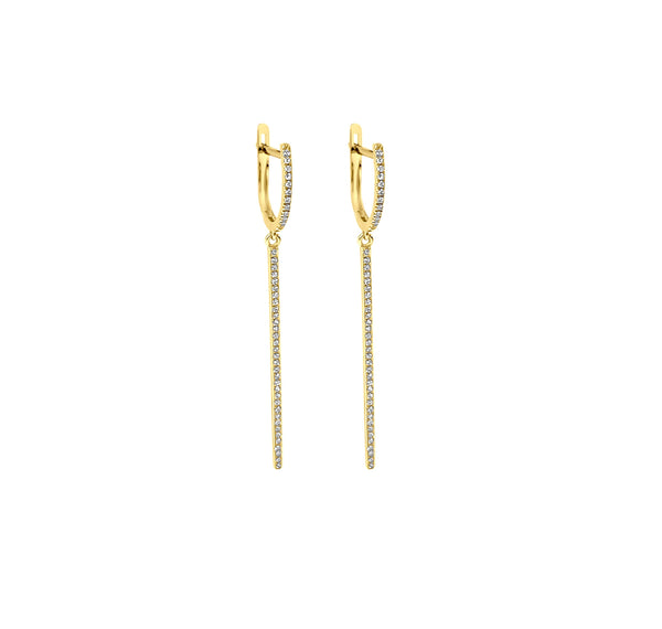 Diamond huggie bar earrings in yellow gold against white background. 