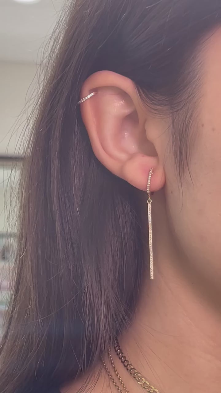 Video showing diamond huggie bar dangle earrings displayed on model. 